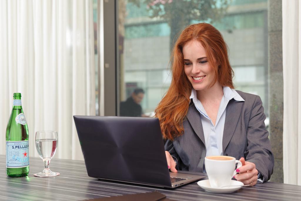فندق ليوناردو سيتي تاور تل أبيب Giv'atayim المظهر الخارجي الصورة A woman working on a laptop